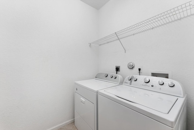 laundry room with independent washer and dryer and light tile patterned floors