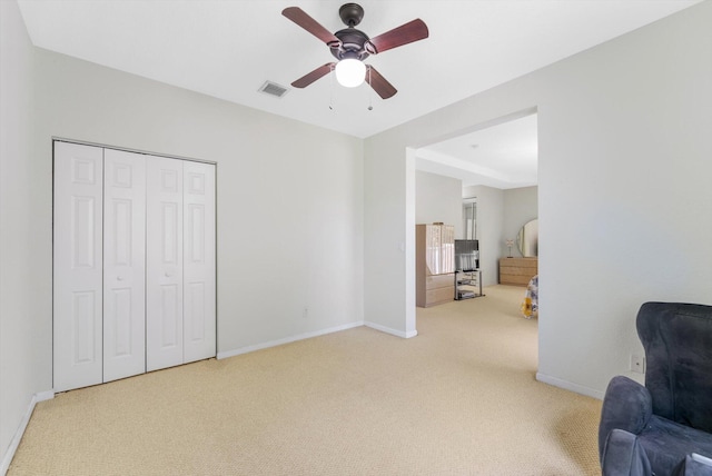 sitting room with ceiling fan and carpet