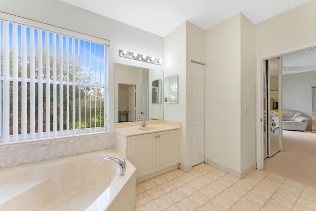 bathroom with tile patterned flooring, vanity, and a relaxing tiled tub