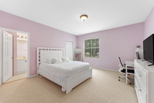 bedroom featuring connected bathroom, light carpet, and a closet