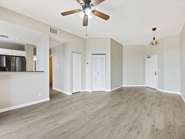 unfurnished living room featuring ceiling fan and light hardwood / wood-style floors