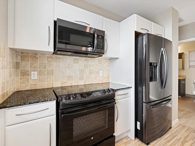 kitchen with white cabinets, stainless steel appliances, and light hardwood / wood-style floors