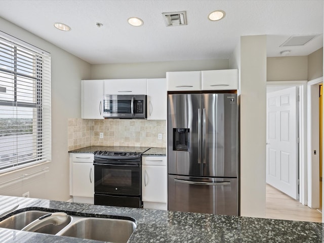 kitchen featuring backsplash, dark stone countertops, white cabinetry, and stainless steel appliances