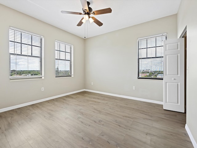 spare room featuring light hardwood / wood-style floors, a wealth of natural light, and ceiling fan