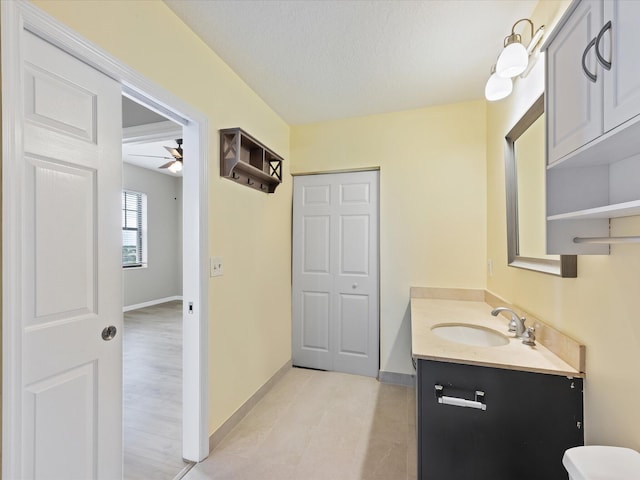 bathroom featuring ceiling fan, a textured ceiling, and vanity