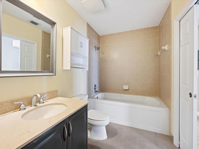 full bathroom featuring tile patterned flooring, tiled shower / bath combo, toilet, and vanity