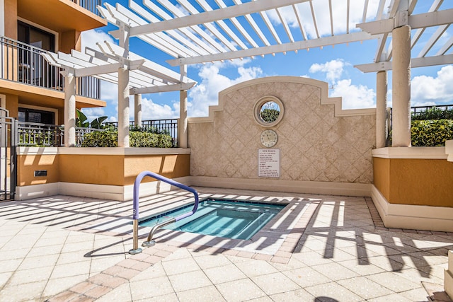 view of pool with a community hot tub and a pergola