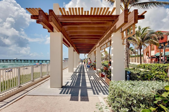 view of patio / terrace featuring a water view and a beach view