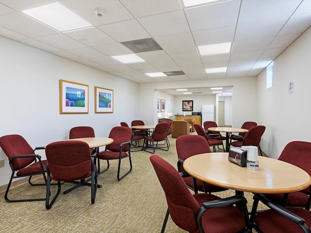 dining room with a drop ceiling and light colored carpet