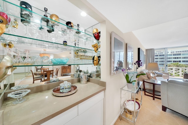 bar with lofted ceiling and white cabinetry