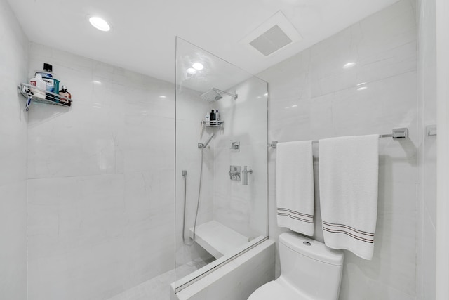 bathroom with tiled shower and toilet