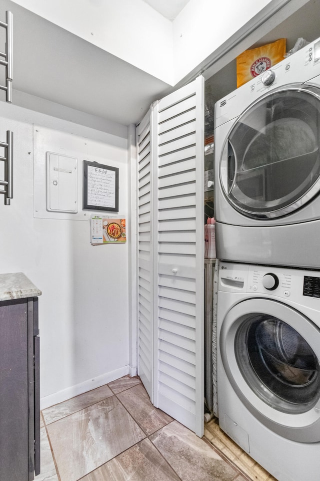 laundry area featuring stacked washer / dryer and light hardwood / wood-style floors