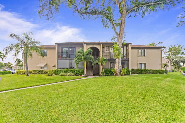 view of front of home featuring a balcony and a front yard