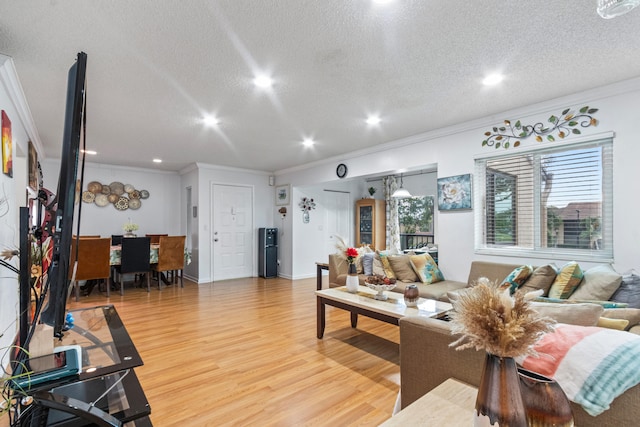 living room with a textured ceiling, crown molding, and hardwood / wood-style flooring