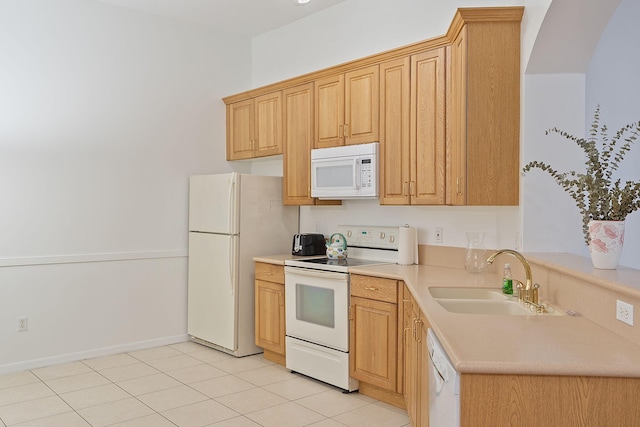 kitchen with light tile patterned floors, white appliances, light brown cabinetry, and sink