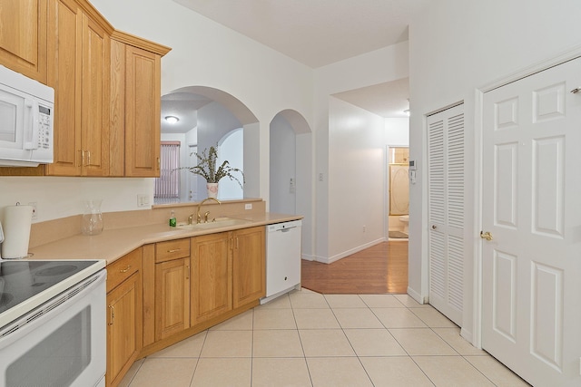 kitchen featuring light wood-type flooring, white appliances, and sink