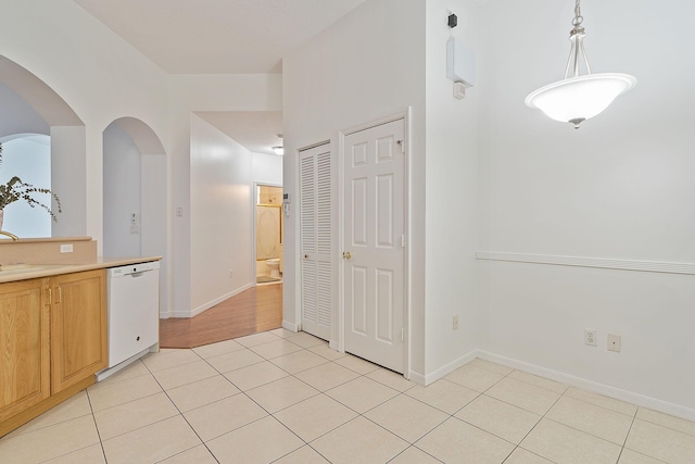 interior space with white dishwasher, decorative light fixtures, and light wood-type flooring