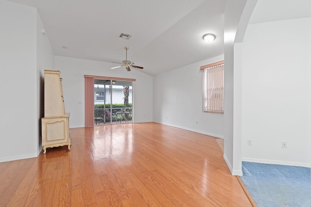 spare room featuring vaulted ceiling, a textured ceiling, ceiling fan, and light hardwood / wood-style floors