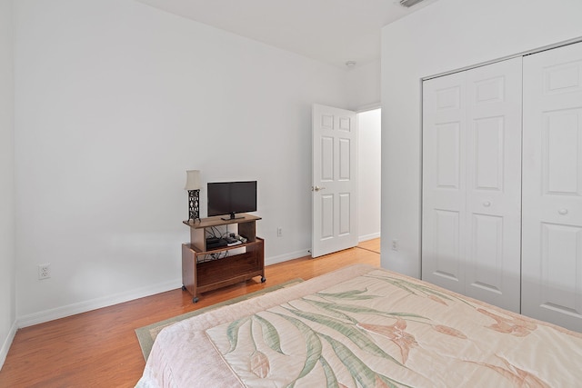 bedroom with light wood-type flooring and a closet