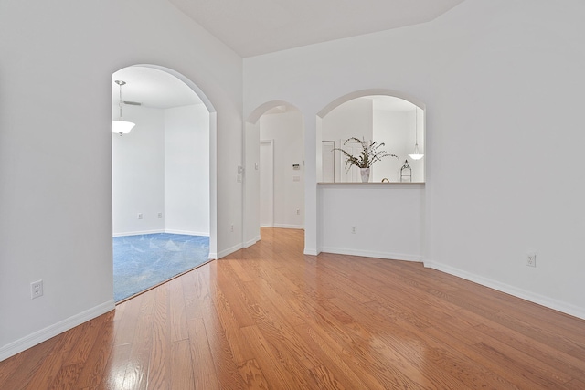 unfurnished room featuring vaulted ceiling and light hardwood / wood-style floors