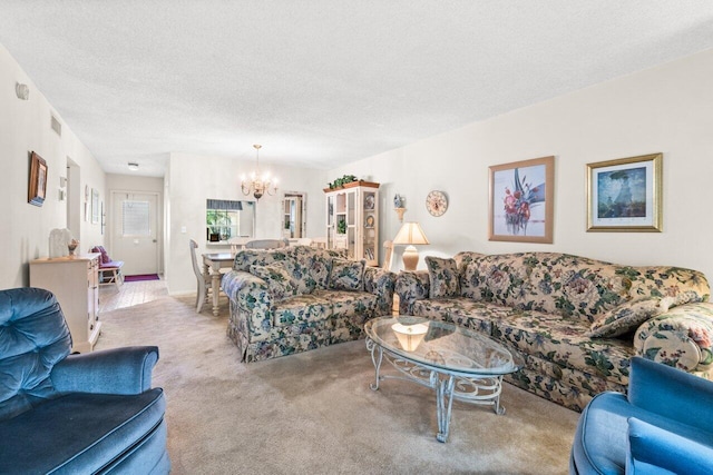 living room with light carpet, a textured ceiling, and an inviting chandelier