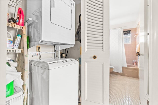 clothes washing area with tile patterned flooring and stacked washing maching and dryer