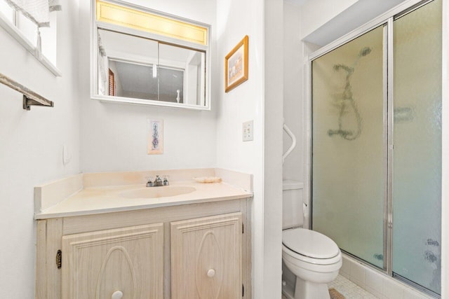 bathroom with vanity, toilet, a shower with shower door, and tile patterned floors