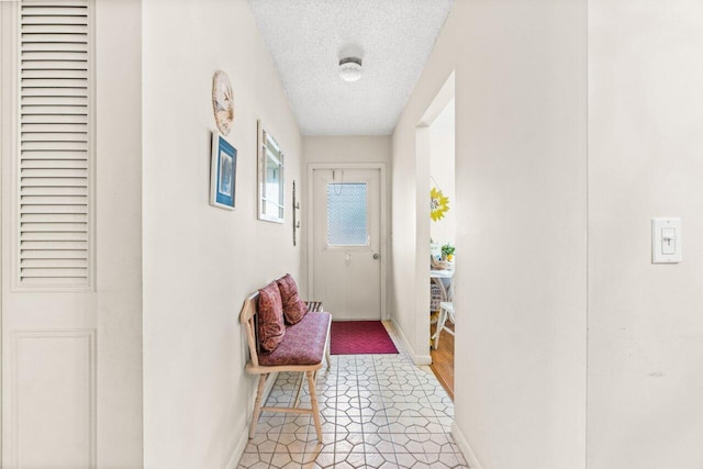 doorway to outside featuring a textured ceiling