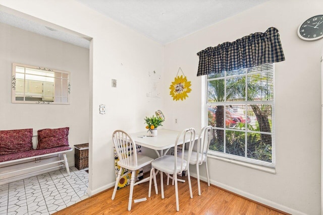 dining area with hardwood / wood-style flooring and a textured ceiling