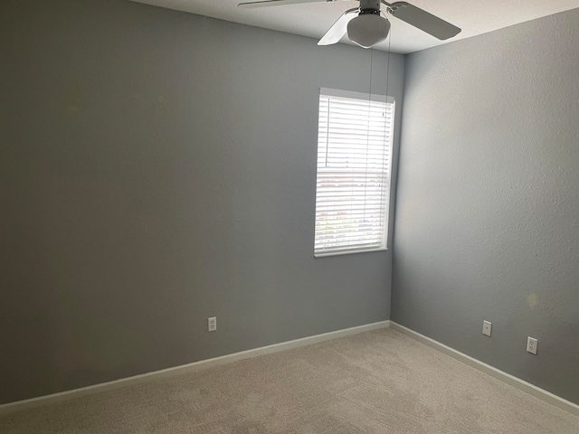 carpeted spare room featuring ceiling fan