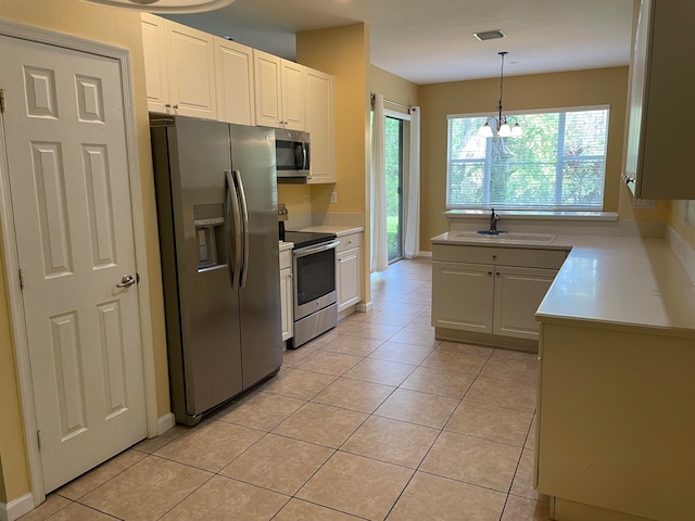 kitchen with appliances with stainless steel finishes, white cabinetry, sink, and an inviting chandelier