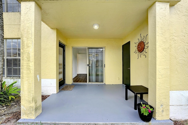 view of exterior entry featuring a patio and stucco siding