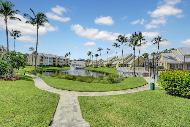 view of community with a water view and a yard