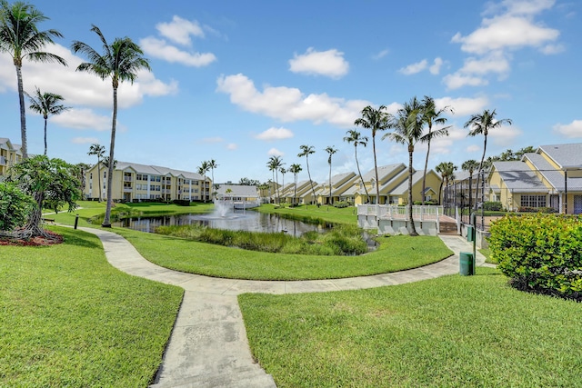view of home's community featuring a water view, a residential view, and a lawn