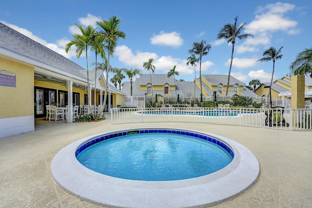 community pool with a residential view, a patio area, fence, and ceiling fan