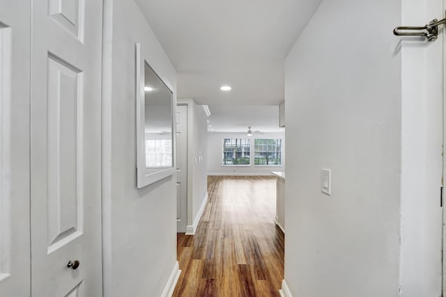 hall featuring recessed lighting, baseboards, and dark wood finished floors