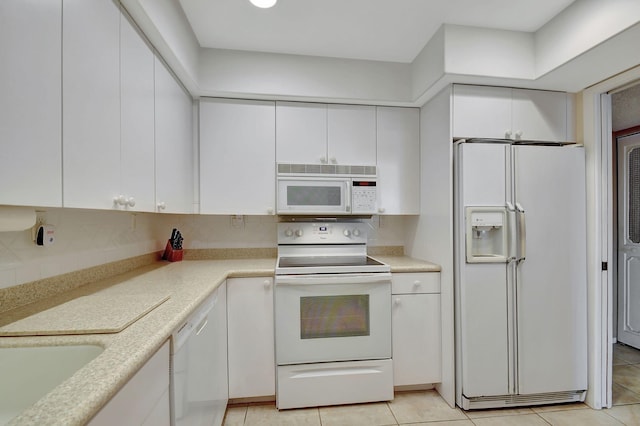 kitchen with backsplash, white cabinetry, and white appliances