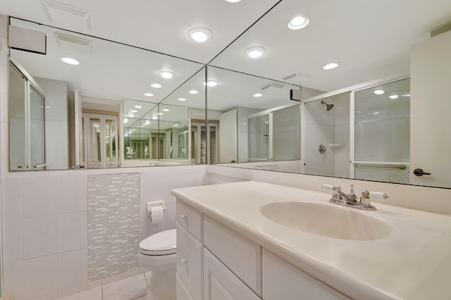 bathroom featuring tile patterned floors, vanity, toilet, and a shower with door