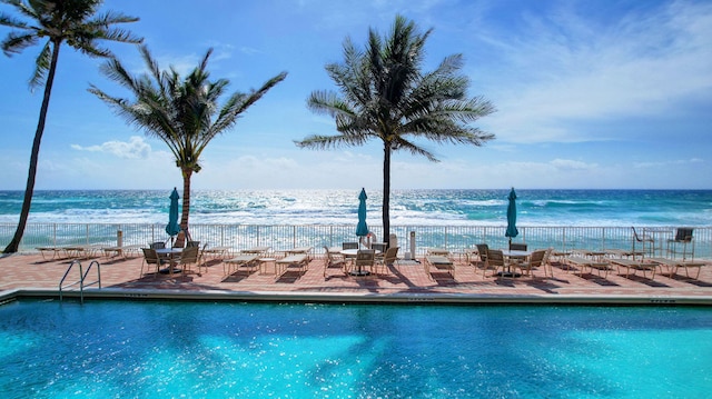 view of pool with a water view and a patio area