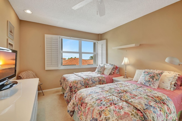 carpeted bedroom with ceiling fan and a textured ceiling