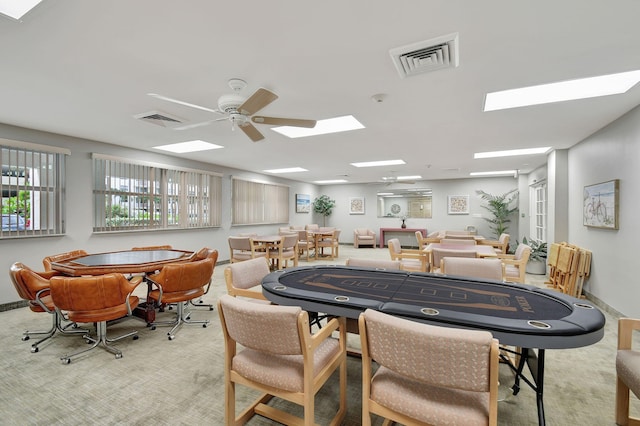 rec room with ceiling fan and light carpet