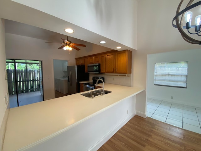 kitchen with appliances with stainless steel finishes, light hardwood / wood-style flooring, independent washer and dryer, and ceiling fan