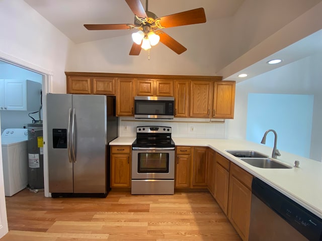 kitchen with stainless steel appliances, sink, ceiling fan, lofted ceiling, and washer / clothes dryer