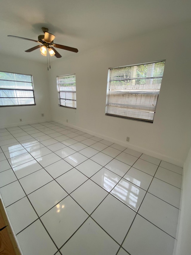 tiled spare room with ceiling fan