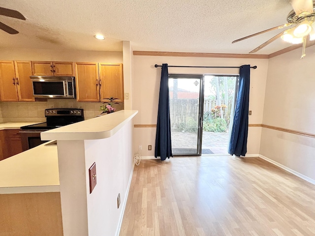 kitchen featuring light hardwood / wood-style floors, decorative backsplash, electric range, a textured ceiling, and ornamental molding