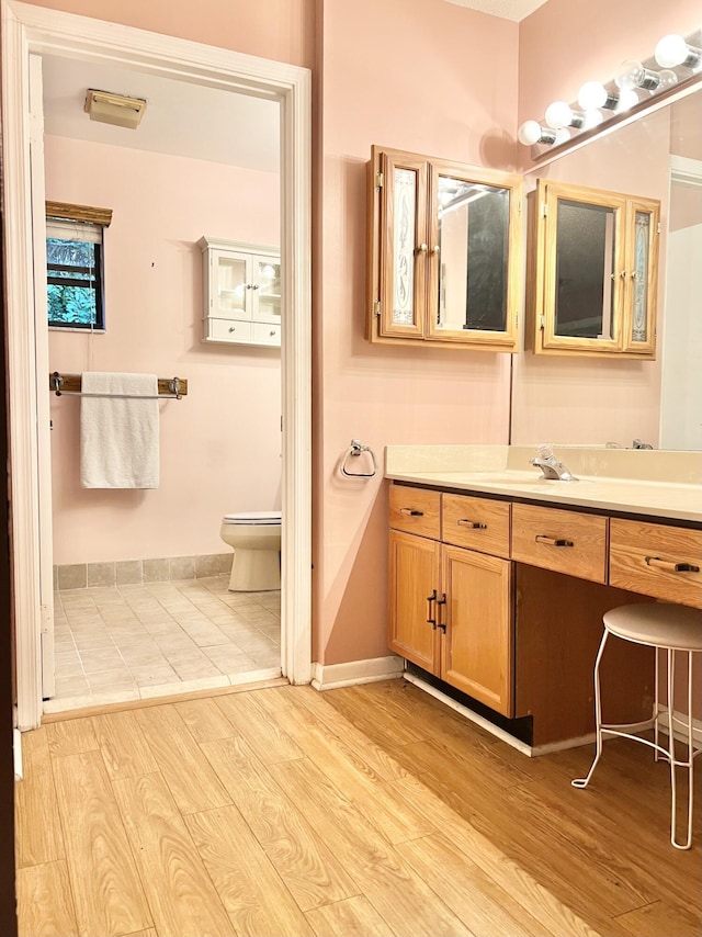 bathroom featuring toilet, vanity, and hardwood / wood-style flooring