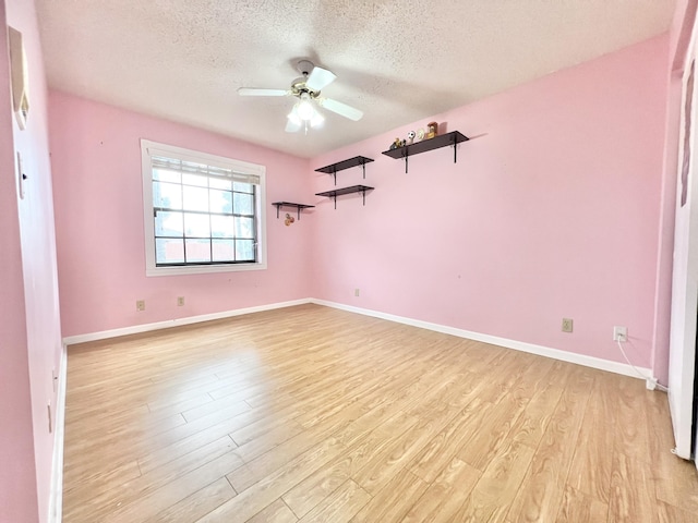 spare room with light wood-type flooring, ceiling fan, and a textured ceiling