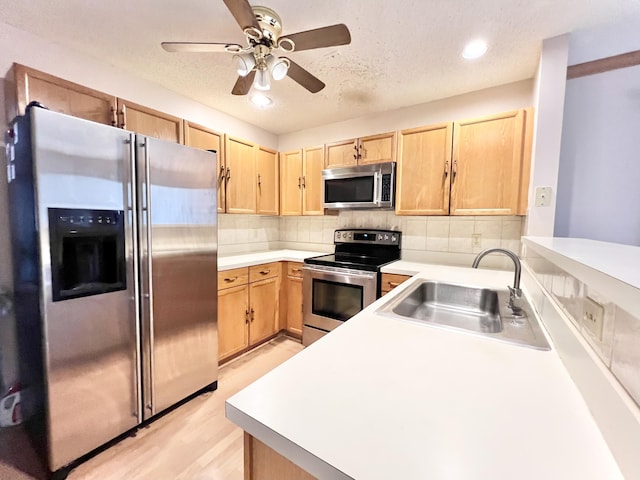 kitchen with ceiling fan, backsplash, sink, appliances with stainless steel finishes, and light brown cabinets