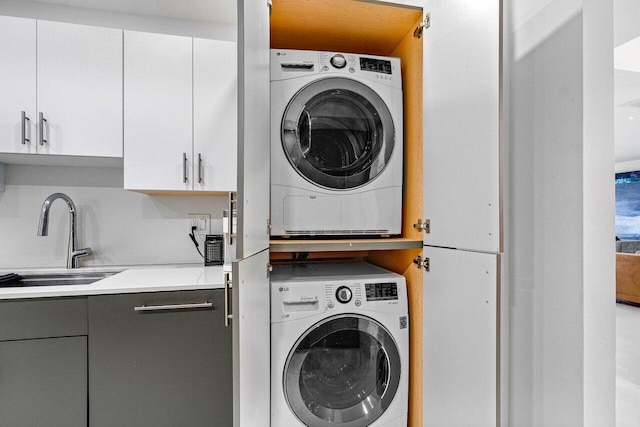 laundry room with stacked washer / dryer and sink