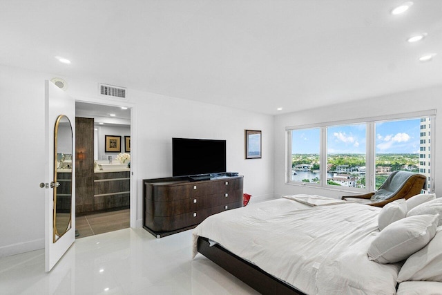 bedroom featuring connected bathroom and light tile patterned flooring